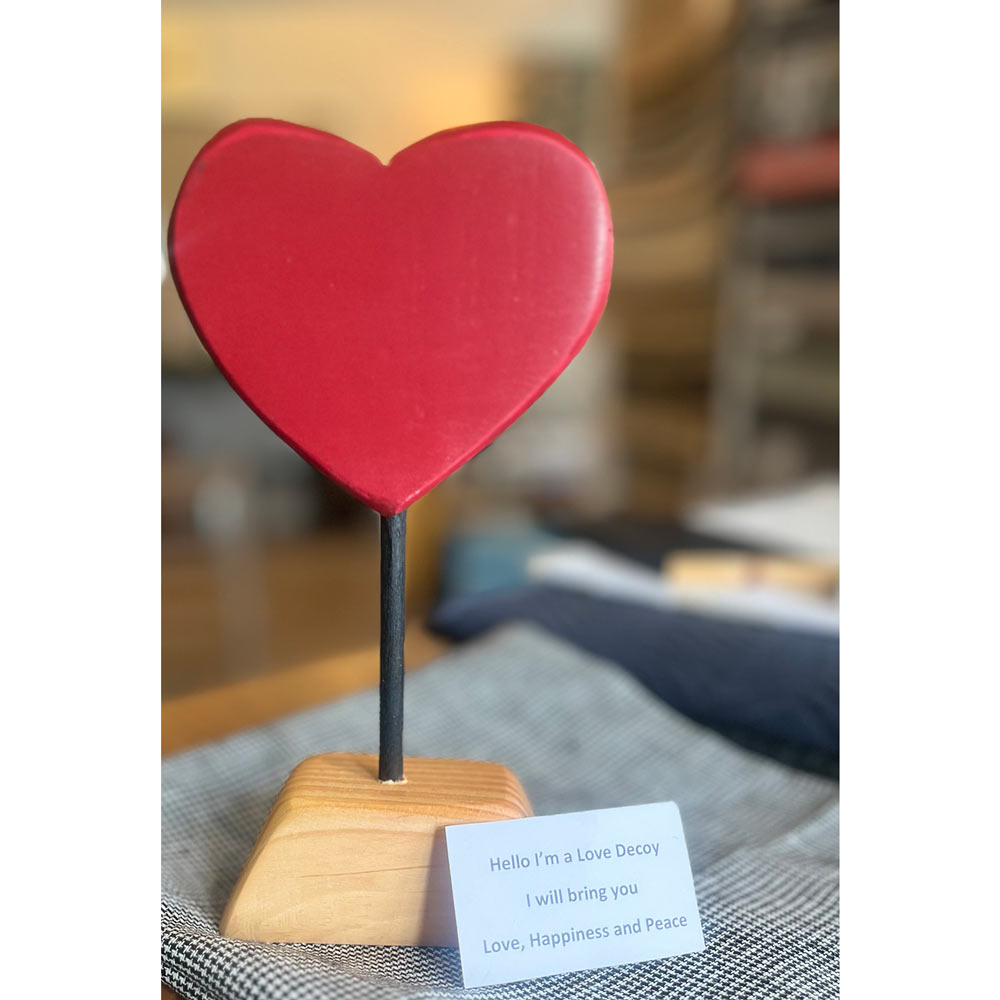 heart-on-a-wood-stand-with-signage-about-being-a-love-decoy